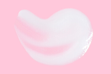 A smear of greasy. cream on a pink background.