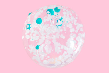 smears and drops of transparent gel with blue granules. On a pink background.