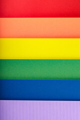 Rainbow flag from stripes of multicolored paper, close up. LGBT Pride month concept