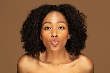 Closeup of playful topless young black woman showing kissing lips