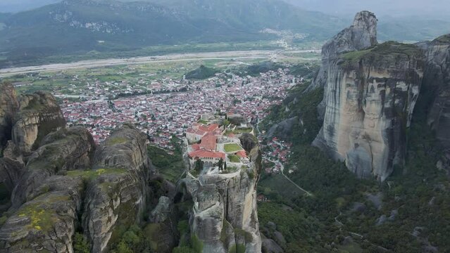 Aerial view of The Holy Trinity Orthodox Monastery with Kalabaka town in background, Meteora, Kalabaka, Thessaly, Greece.
