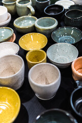 Top view flay lay composition of table full of different colours shapes and sizes handmade speckled pottery ceramics cups bowls