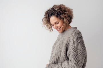 Portrait of a smiling woman in sweater looking away over white background