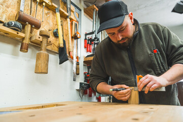 shot of carpenter's hands using set square tool wor a wooden plank, making wooden products. High quality photo