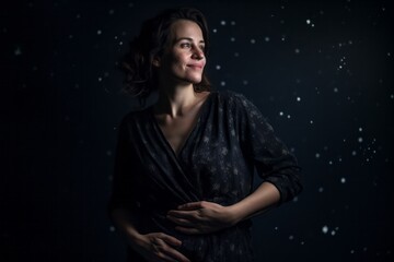 Portrait of a beautiful young woman in a black dress on a dark background
