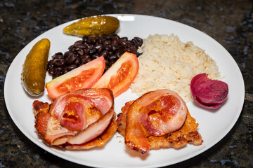 Traditional Brazilian daily meal, black beans, rice, meat, salad. real food