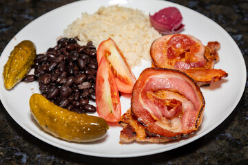 Traditional Brazilian daily meal, black beans, rice, meat, salad. real food