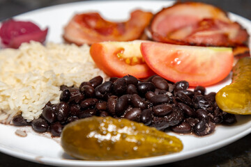 Traditional Brazilian daily meal, black beans, rice, meat, salad. real food