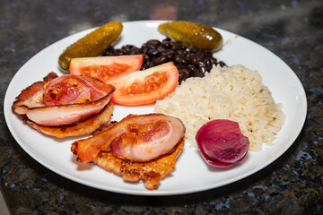 Traditional Brazilian daily meal, black beans, rice, meat, salad. real food