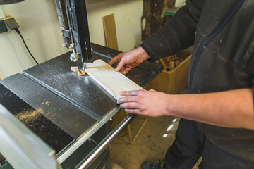 Hands of carpenter using a wood milling machine to cut shapes from wooden plank. High quality photo