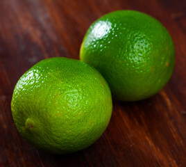 Image of fresh limes on wooden surface in home kitchen, nobody