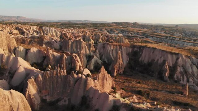 Cappadocia aerial drone view to sunset in Red and Rose valley rock formation, ancient cave churches. Goreme, Cappadocia, Turkey