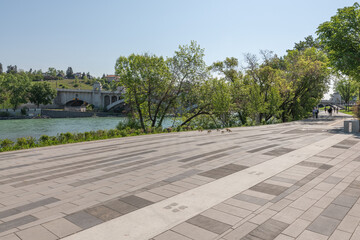 Fototapeta premium Scenic views along the Bow River pathway area for pedestrians, bicycles during summer spring on beautiful blue sky day.