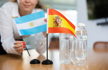 Little flag of Spain on table with bottles of water and flag of Argentina put next to it by...