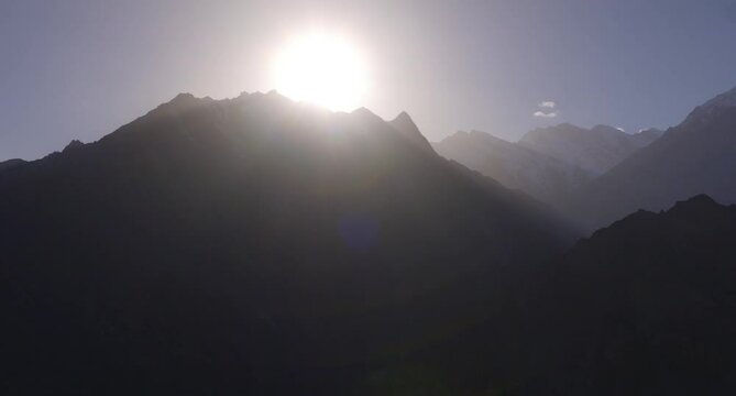 Aerial view of the sun setting in the back of high peak in Hunza Vallley located in the Karakoram range of the Himalayas, Gilgit Baltistan, Pakistan
