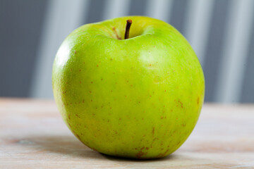 Ripe green apple on wooden table