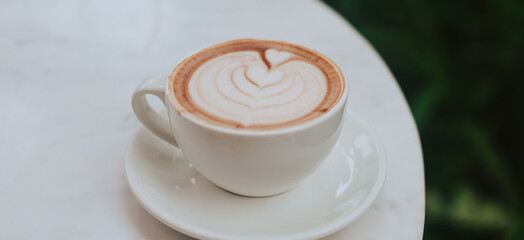 Banner with a cup of coffee on a round table. Cappuccino for breakfast