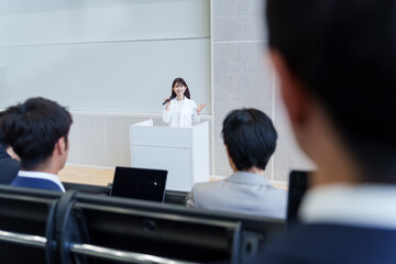 プレゼンをする白衣を着た女性