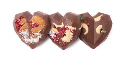 Tasty chocolate heart shaped candies with nuts on white background, top view