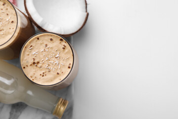 Delicious coffee with coconut syrup on white table, flat lay. Space for text