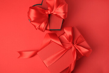 Beautiful gift boxes with bows on red background, flat lay
