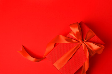 Beautiful gift box with bow on red background, top view. Space for text