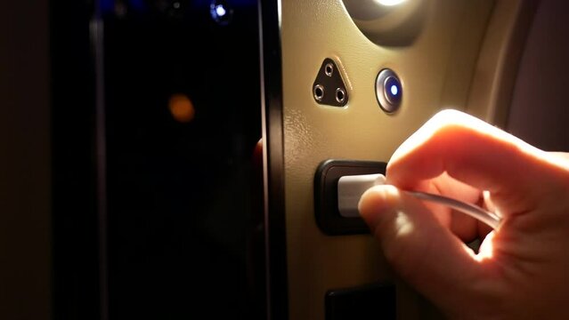 The motion of a man inserting a USB cable for charging his smartphone while traveling with 4k resolution.