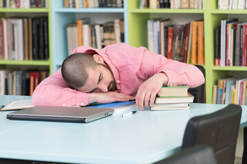 Male Student Sleeping In Library