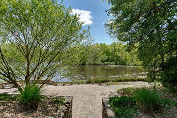 Lake with Stone Patio Walking Path and Tree Landscape