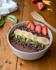 Smoothie bowl with fresh fruits and chocolate beans 