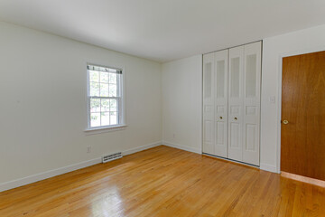 Empty White Bedroom Interior with Hardwood Floors and Blank Walls with Closet Doors Mockup