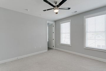 Clean Empty Residential Modern Bedroom Interior with Grey Walls and Light Carpet