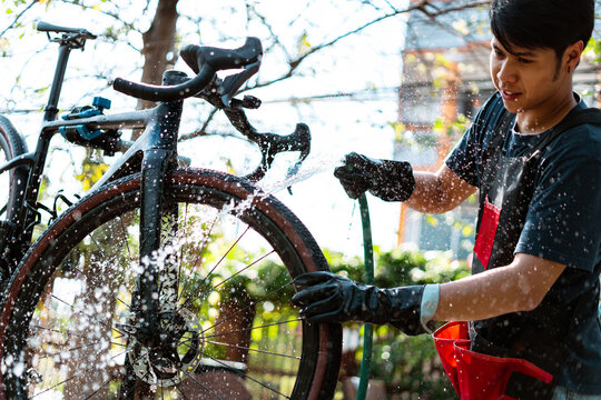 Asian bike mechanic washing a customer's bike.