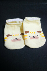 Cute baby socks yellow with a hamster face on them