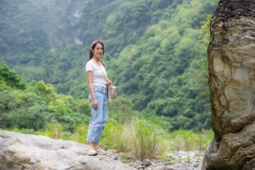 Naklejka premium Woman stand on the rock into forest