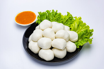 Fish balls ready to be served in a white container.