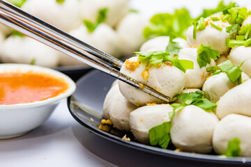 Fish balls ready to be served in a white container.