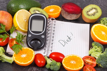 Glucometer for measuring sugar level, fruits with vegetables and notepad with word diet. Healthy food for diabetic concept