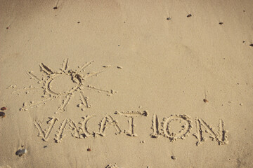 Inscription vacation and shape of sun on sand at beach. Summer time. Place for text
