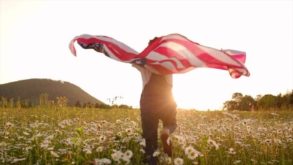 Selective focus of patriotic little girl with american flag running in daisy field on background summer mountains at sunset. 4th of July - Independence day, celebration, memorial Veterans, election