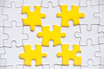 Fototapeta premium Top view of missing jigsaw puzzle with customizable space for text. Copy space with yellow background