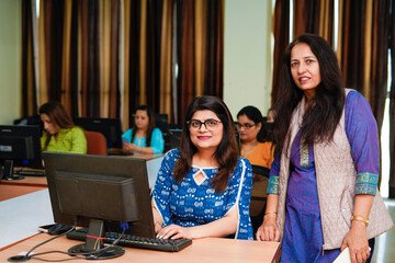 Senior woman showing some detail in computer to woman at office
