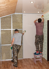 Workers install a plasterboard wall