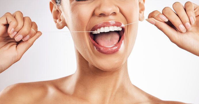 Smile, dental and woman flossing teeth in studio for hygiene, wellness or fresh breath on grey background. Hands, floss and lady relax with mouth, tooth or cleaning for oral care or cavity prevention