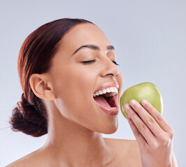 Apple, bite or happy woman in studio eating on white background for healthy nutrition or clean...