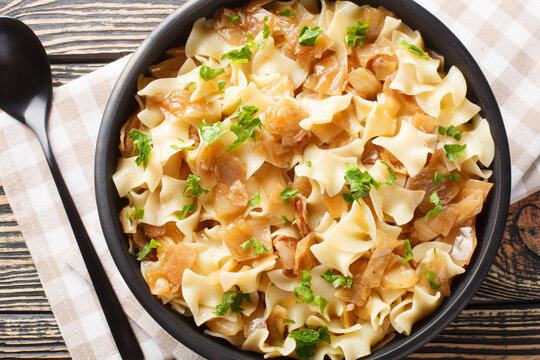 Austrian noodles with stewed white cabbage and caramelized onions close-up in a bowl on the table. Horizontal top view from above