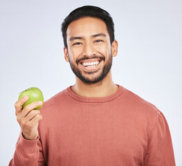 Man in portrait, apple and nutrition with health and diet with eating isolated on white background. Male person with smile, green fruit and organic with healthy food, detox and lose weight in studio
