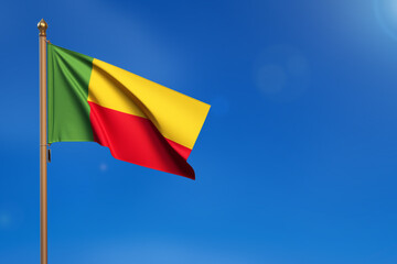 Benin. Flag blown by the wind with blue sky in the background.
