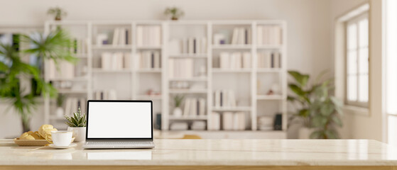 Workspace with laptop mockup on a table in a white living room with large bookshelf.