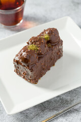 Cake with profiteroles with tea on stone table